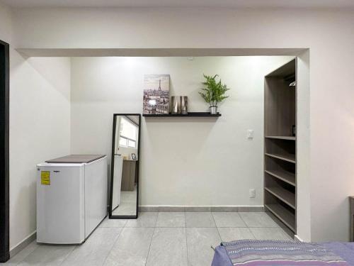 a room with a small refrigerator and a mirror at Casa Yautepec Condesa in Mexico City