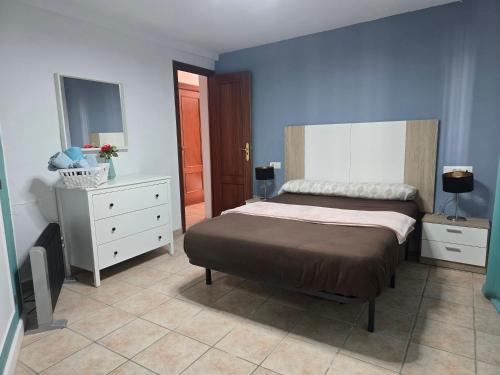 a bedroom with a bed and a dresser and a mirror at Casa Clavel in Ronda
