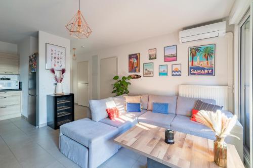 un salon avec un canapé bleu et une table dans l'établissement Appartement charmant au porte de Montpellier, à Saint-Jean-de-Védas