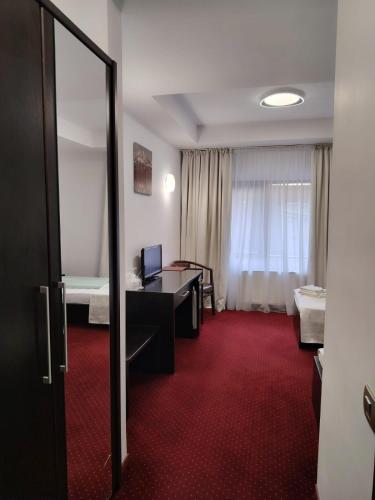 a room with a desk and a room with two beds at Hotel Transilvania Zalău in Zalău