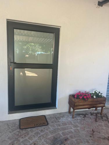 a door with a window and a table with flowers at @144 Rabe in Mokopane