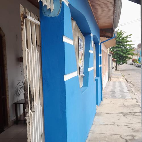 a blue wall of a building with two windows at Casa & Hospedagem Carol in Cachoeira Paulista