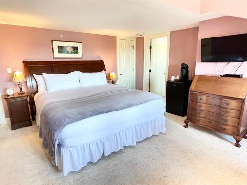 a bedroom with a large bed and a flat screen tv at Adair Country Inn & Restaurant in Bethlehem