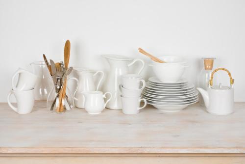 a group of white cups and plates on a shelf at Luxe 220, Unit 5 - Adjacent City View Suites in Wilmington