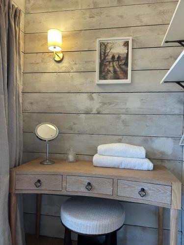 a wooden wall with a desk and a chair at Luxury Boutique retreat, hot tub, dog friendly in Hanmer