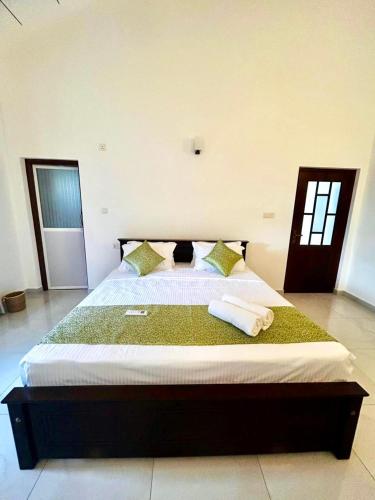a bedroom with a large bed with two towels on it at Neem Aura Home Stay in Seeduwa