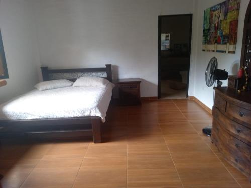 a bedroom with a bed and a dresser and a wooden floor at Finca el Manantial in Papagalleros