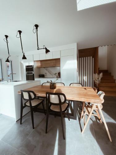 une cuisine et une salle à manger avec une table et des chaises en bois dans l'établissement Villa avec piscine privée au calme, à BIQ