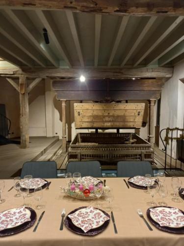une table avec des assiettes et des verres à vin devant un organe dans l'établissement Le pressoir de Nestor, à Monthelon