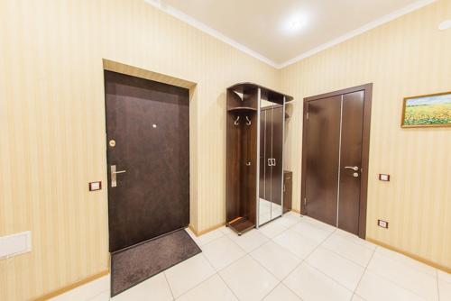 a bathroom with two doors and a tile floor at Botanic Towers the house has a shelter in Kyiv