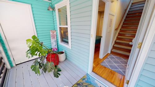 a front porch of a blue house with a plant at Flip Flop Casual in Folly Beach