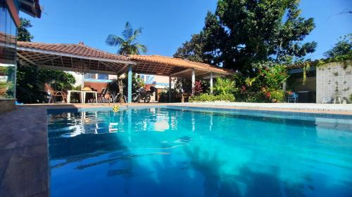 a swimming pool in a house with blue water at Suites Baleia Verde in São Sebastião