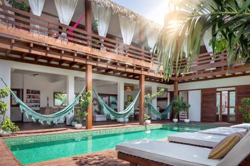 a villa with a swimming pool and hammocks at Villa Métisse in Jericoacoara