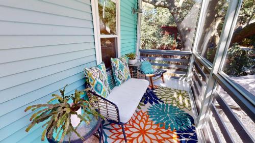 a porch with two chairs and a table on it at Flip Flop Casual in Folly Beach