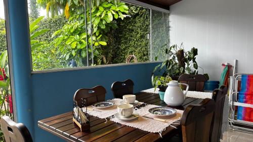 a wooden table with plates and cups on top of it at Casa Azul in Penha