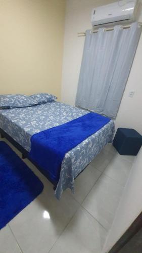 a bedroom with two beds with blue sheets and a window at FLAT BRISA do MAR in Pitimbu