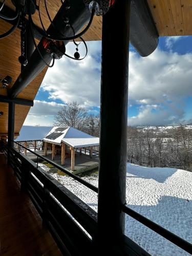 a view of a building in the snow from a window at Domi Chalet in Şişeşti