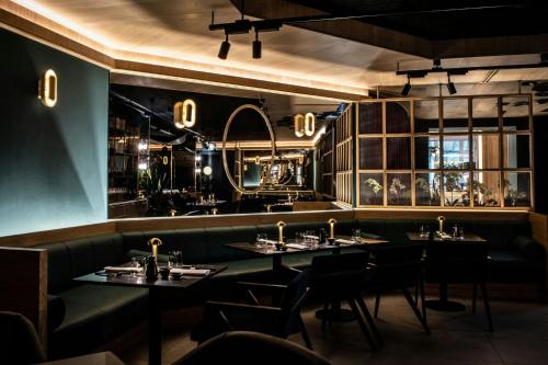 a restaurant with tables and chairs in a room at Sheraton Grand Warsaw in Warsaw