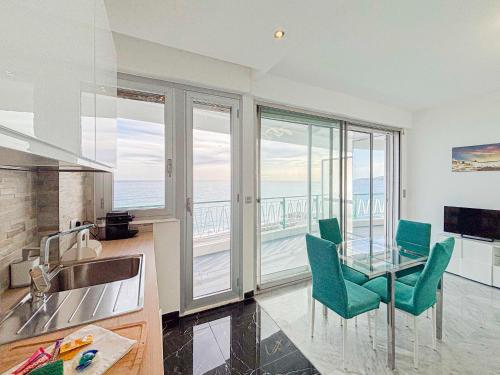 - une cuisine avec une table et des chaises offrant une vue sur l'océan dans l'établissement Promenade des Anglais - Vue Mer, AC, 2pers, à Nice
