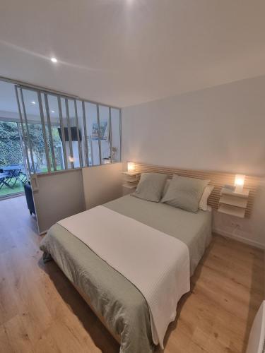 une chambre avec un grand lit blanc avec deux oreillers dans l'établissement Cosy apartment facing parks - Quartier de France, à Vichy