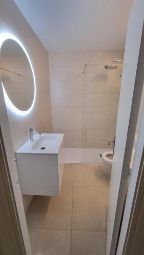 a white bathroom with a sink and a toilet at HOLIDAYS MENORCA Cala Galdana in Cala Galdana