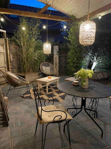 a patio with a table and chairs and lights at Le Nichoir in Frélinghien