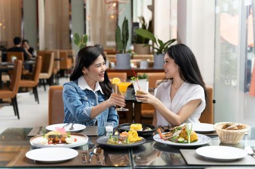 two women sitting at a table eating food at Marriott Executive Apartments Sukhumvit Park, Bangkok in Bangkok