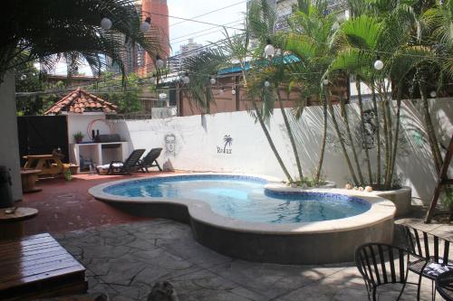 a pool in a courtyard with chairs and trees at Casa Areka in Panama City