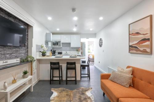an open living room and kitchen with an orange couch at The Lush Apartment Cardiff Central 2 Bedrooms in Cardiff
