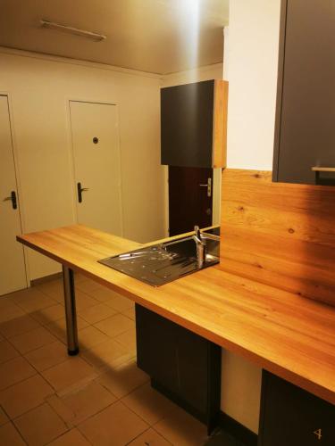 - une cuisine avec un comptoir en bois et un évier dans l'établissement Chambre simple, à Saint-Ouen-lʼAumône