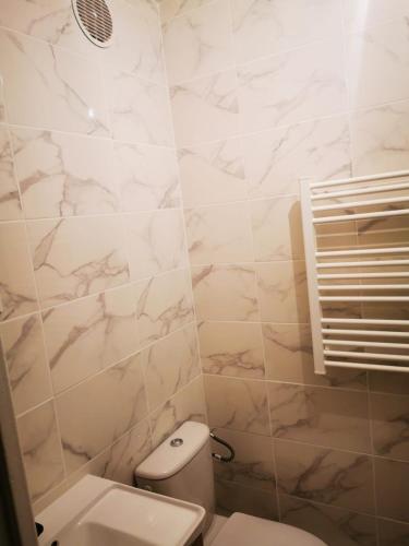 une salle de bain blanche avec des toilettes et un lavabo dans l'établissement Chambre simple, à Saint-Ouen-lʼAumône