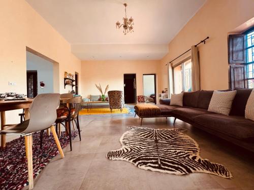 una sala de estar con un sofá y una mesa en Chambre aux portes du désert I Agafay, en Wawizelt