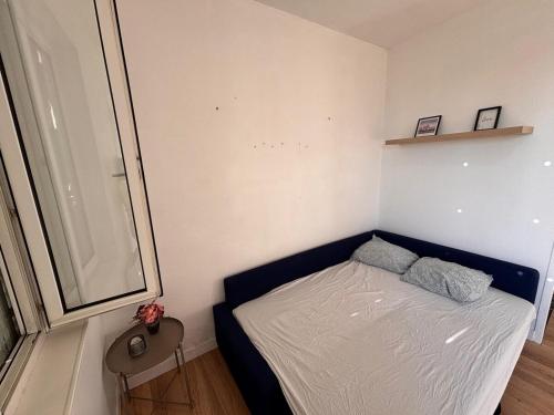 - une petite chambre avec un lit bleu et 2 oreillers dans l'établissement Les Ours - Studio Centre Ville, à Rouen