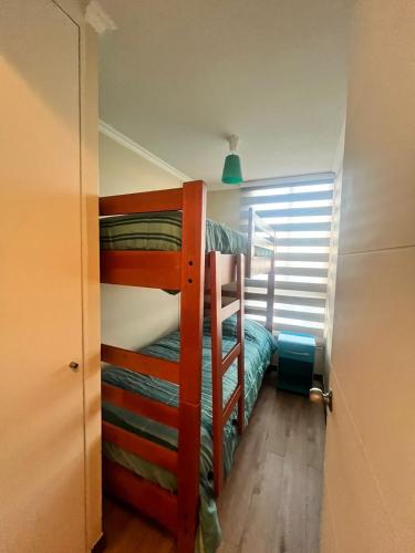 a bedroom with two bunk beds in a room at Depto 3 dormitorios a 10 minutos de la playa Herradura Sindempart in Coquimbo