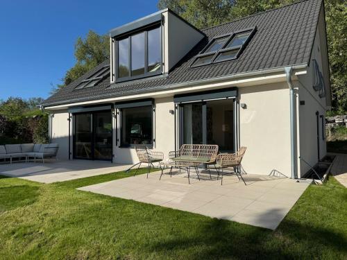 una casa con una mesa y sillas en un patio en Auszeit am Schwielowsee - Moderne Ferienwohnung direkt am Schwielowsee, en Schwielowsee