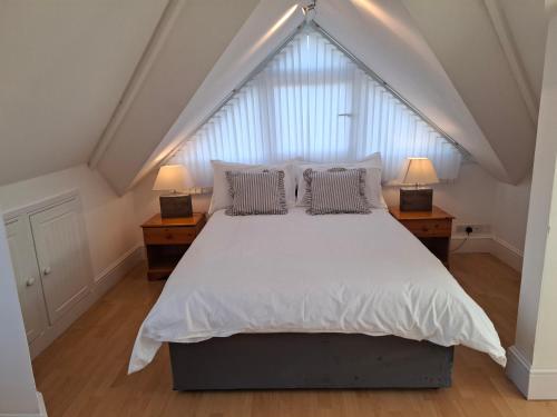 a bedroom with a large white bed with two lamps at Panorama House - 400m from Sandbanks beach in Sandbanks