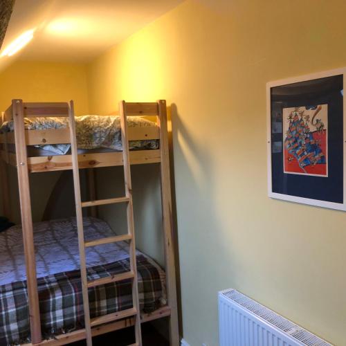two bunk beds in a room with a wall at Llangollen Townhouse 4 bedroom in Llangollen