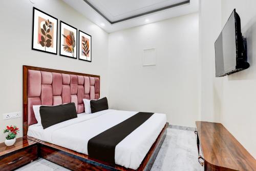 Un dormitorio con una cama y un televisor de pantalla plana. en Super Hotel O BAL GOPAL, en Delhi