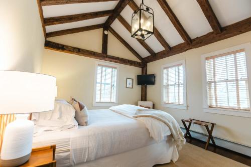 a bedroom with a white bed and windows at Hill Farm Inn - Manchester in Sunderland