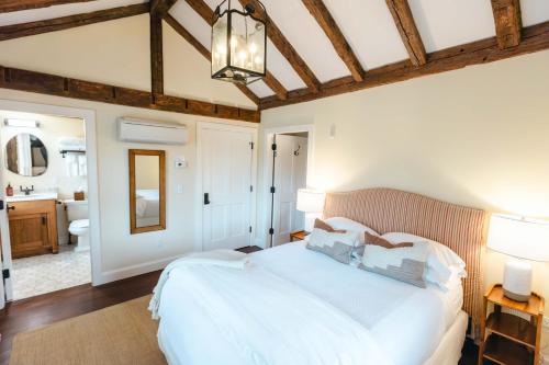 a bedroom with a large white bed and a bathroom at Hill Farm Inn - Manchester in Sunderland
