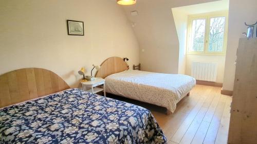 Saint-AlbanにあるCasa Bretonne- Grand terrain- 7mn de la plage-のベッド2台と窓のある寝室