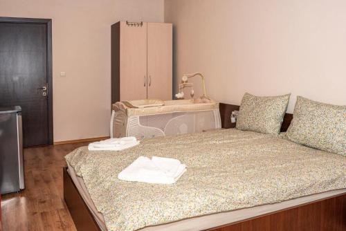 a bedroom with a bed with two towels on it at Апартамент Lina View in Tryavna
