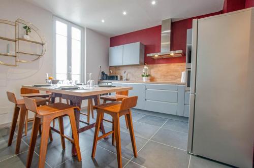une cuisine avec une table, des chaises et un réfrigérateur dans l'établissement L'Art Déco, à Troyes