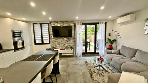 un salon avec un canapé et une table dans l'établissement Appartement standing avec jardin, Clim, wifi, proche des plages, à Six-Fours-les-Plages