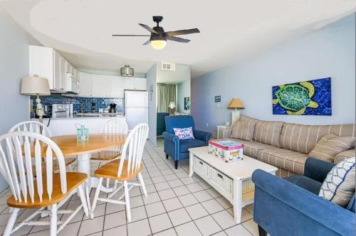 a living room with a couch and a table at Octopus Garden 1BR, King Bed, Indoor & Outdoor Pool in Carolina Beach