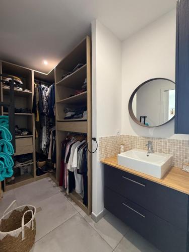 une salle de bain avec un lavabo et un miroir dans l'établissement Serignan villa moderne avec piscine, à Sérignan