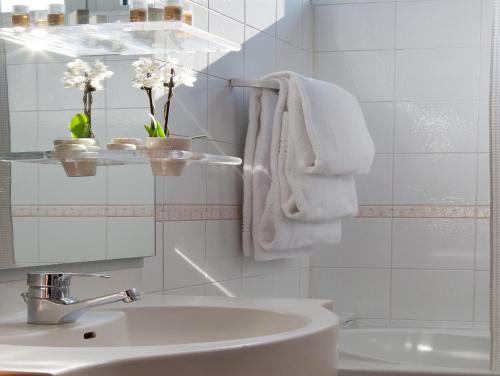 bagno con asciugamani bianchi e lavandino di Hotel Marconi a Padova