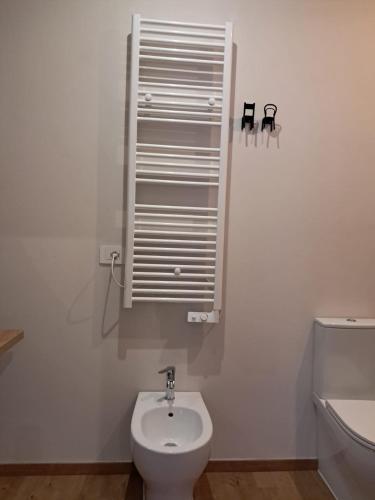 a white bathroom with a toilet and a sink at 8380 La Cantina di Piero&Netta in Montemerano