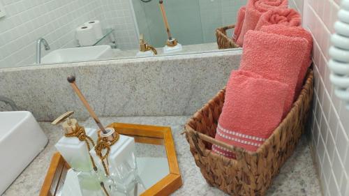 a bathroom with a sink and a mirror and towels at Lindo e novo apto com vista para o mar de Pituba c/garagem in Salvador