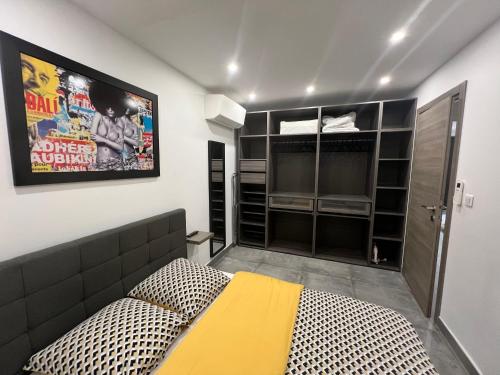 une chambre avec un lit et une télévision au mur dans l'établissement Appartement standing avec jardin, Clim, wifi, proche des plages, à Six-Fours-les-Plages